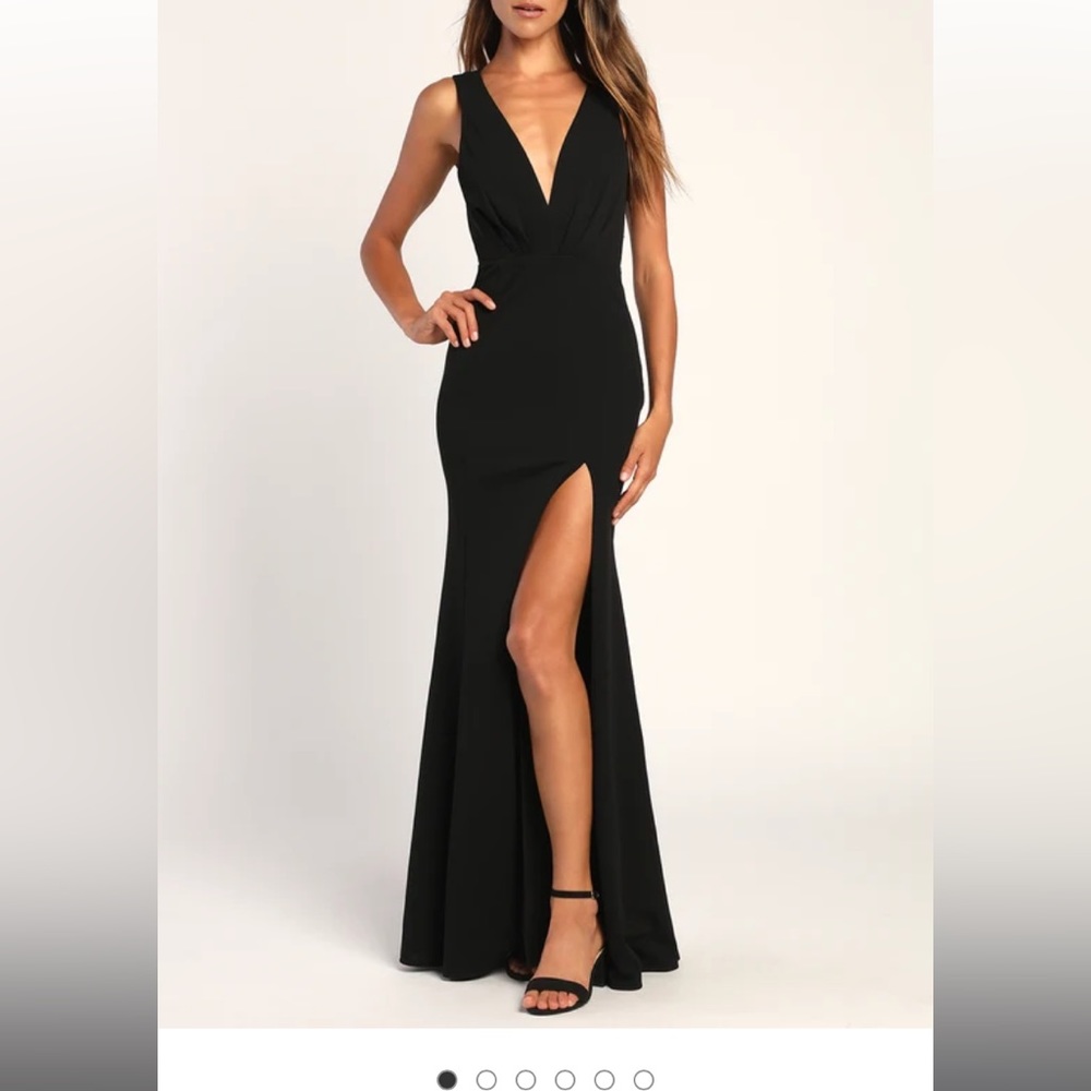 Black floor length gown with thigh high slit and low cut neckline.